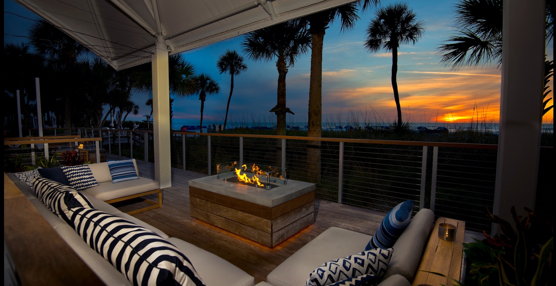 an outdoor fireplace with large sectional surrounding it