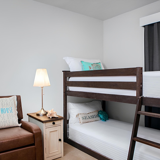 bedroom with small brown chair and bunkbeds