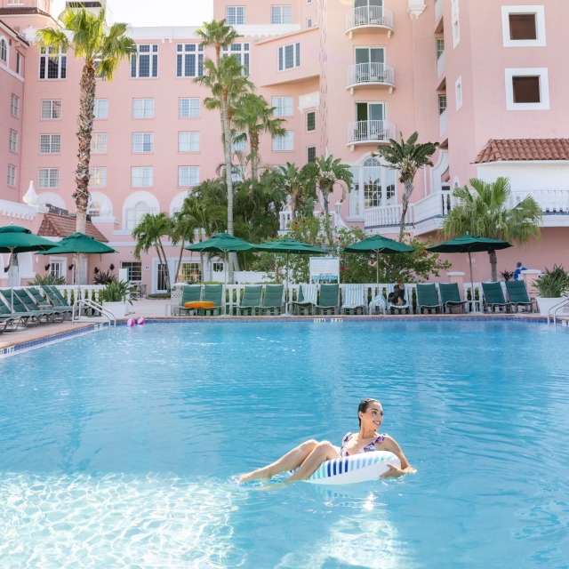 a woman lounging in an inflatable tube in the pool