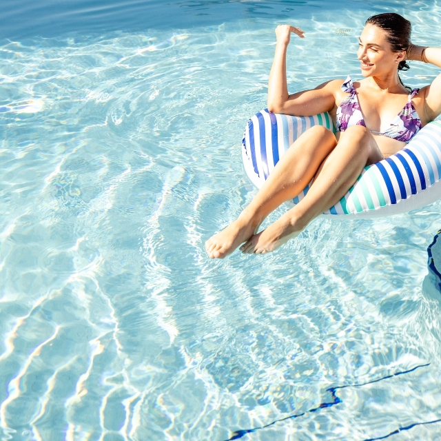 a woman lounging in an inflatable tube in the pool